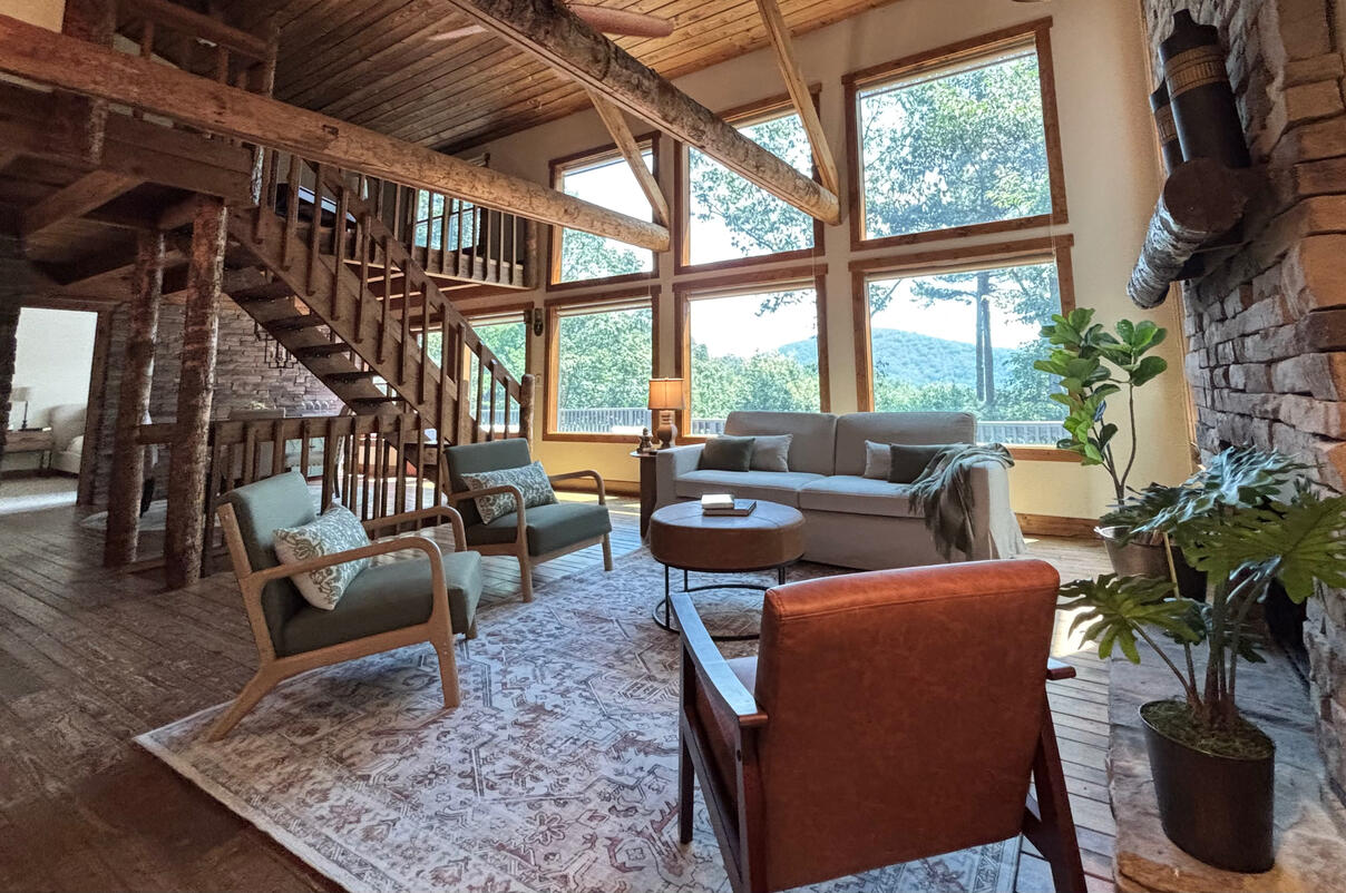 Big Canoe: Oh that stunning view! I just wanted the windows to disappear and continue bringing the outside in with my staging. The beautiful stone wall and fireplace, along with exposed beams made this project delightful.